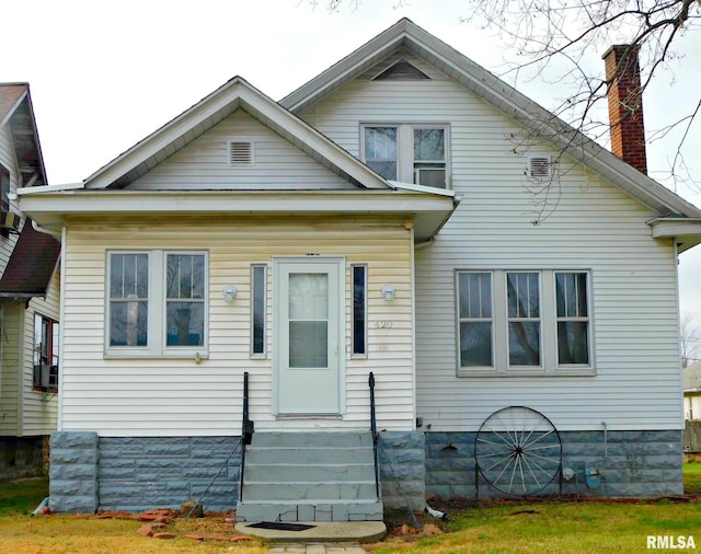 bungalow with entry steps, a chimney, and cooling unit