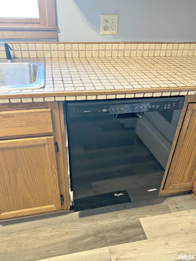 interior space with dishwasher, light wood-style flooring, and a sink