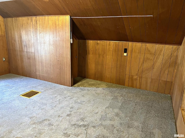 bonus room featuring visible vents, carpet floors, wood ceiling, and wooden walls