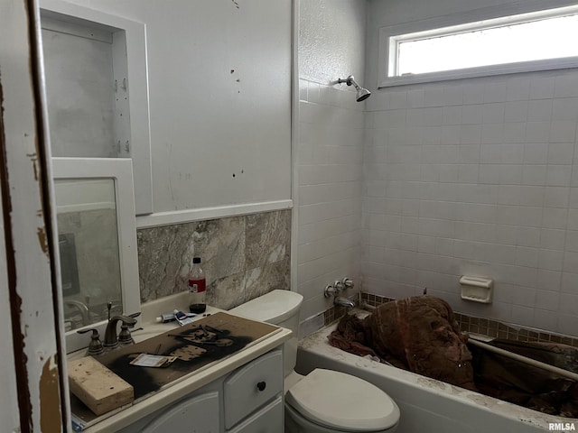 bathroom with toilet, vanity, tile walls, shower / bathing tub combination, and tasteful backsplash