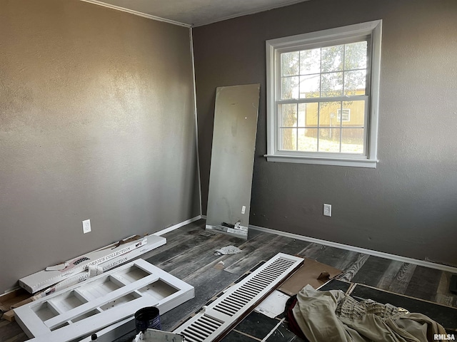 spare room with wood finished floors and baseboards