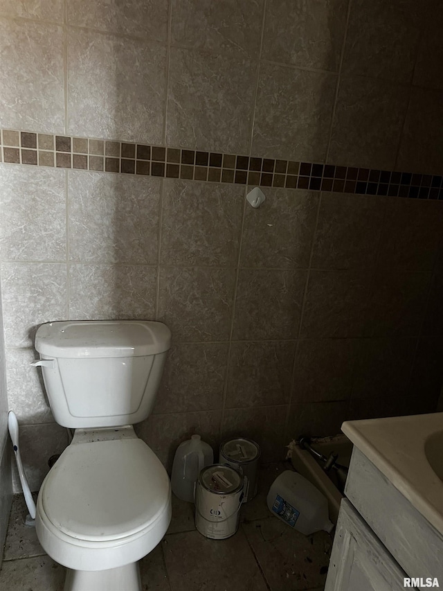 bathroom with tile walls, tile patterned flooring, vanity, and toilet