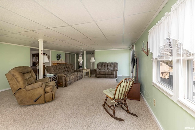 living room featuring carpet flooring, a paneled ceiling, and baseboards