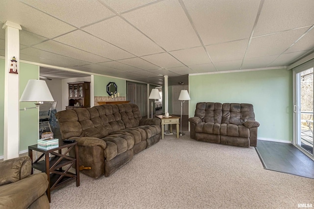 carpeted living area featuring a paneled ceiling and baseboards