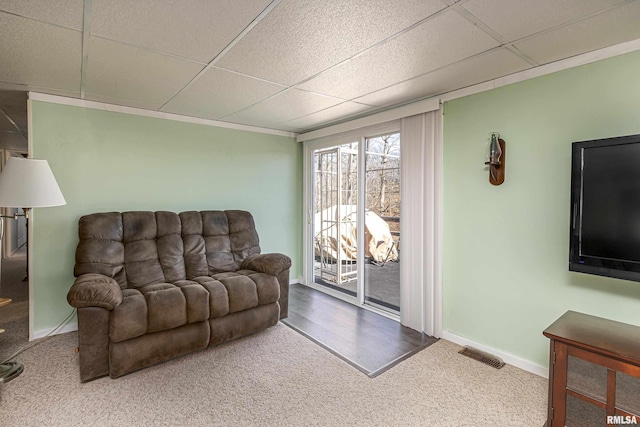 living room with a paneled ceiling, baseboards, and visible vents