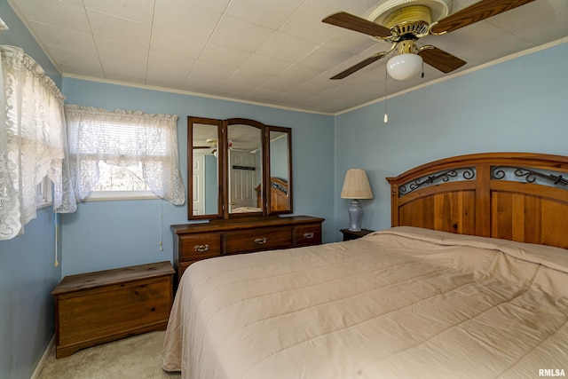 carpeted bedroom featuring ceiling fan and crown molding