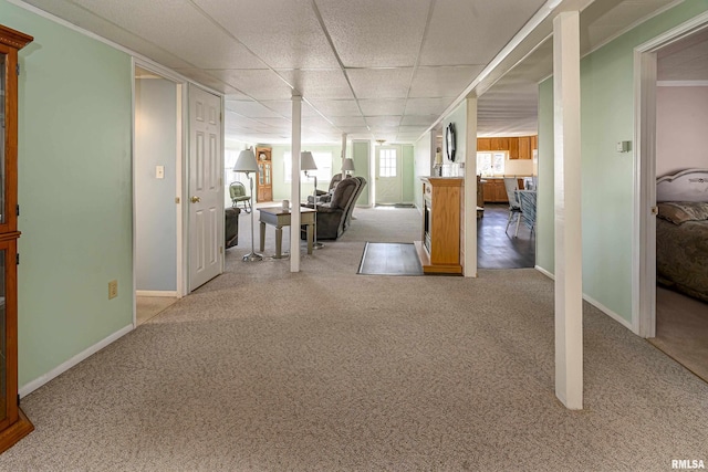 interior space with carpet, a paneled ceiling, and baseboards