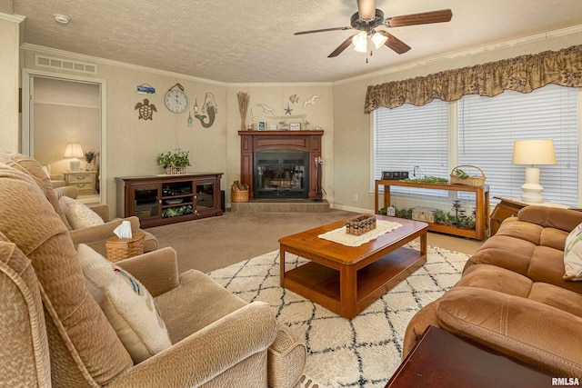 living room featuring carpet, a fireplace, visible vents, ornamental molding, and a textured ceiling