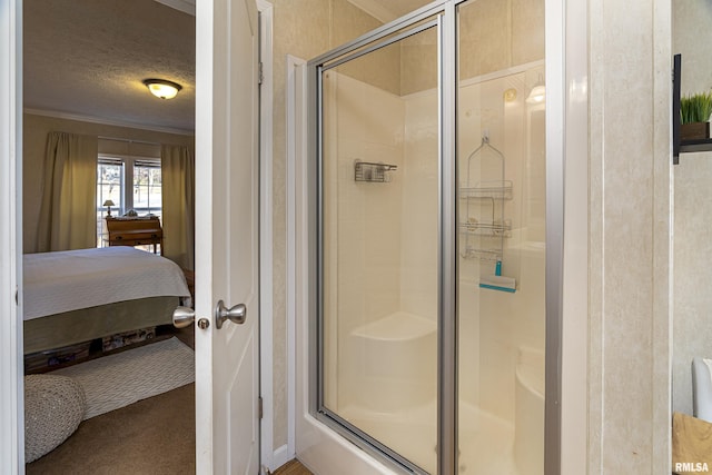 ensuite bathroom featuring a shower stall, crown molding, a textured ceiling, and ensuite bath