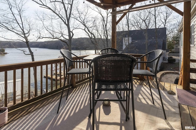 view of patio / terrace with outdoor dining space and a deck with water view