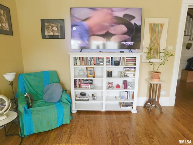 living area with wood finished floors and baseboards