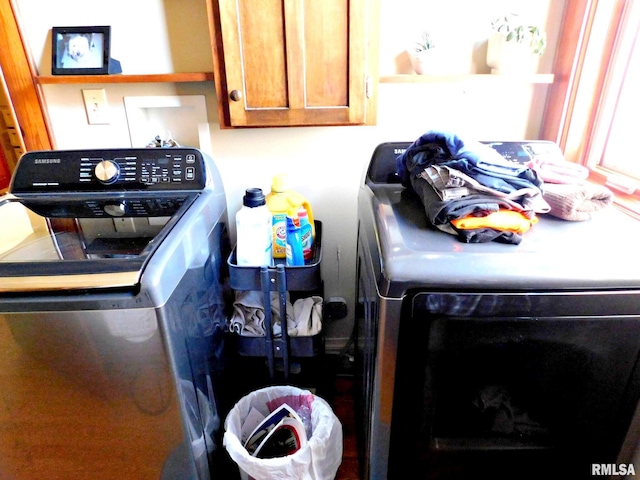 clothes washing area featuring washer / clothes dryer and cabinet space