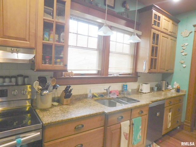 kitchen featuring tasteful backsplash, appliances with stainless steel finishes, pendant lighting, and a sink