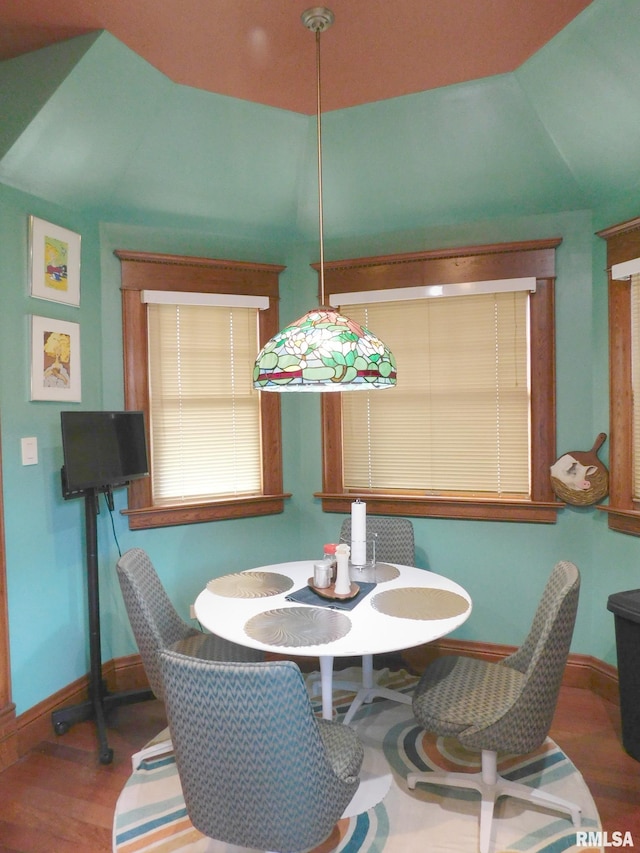 dining space with baseboards and wood finished floors