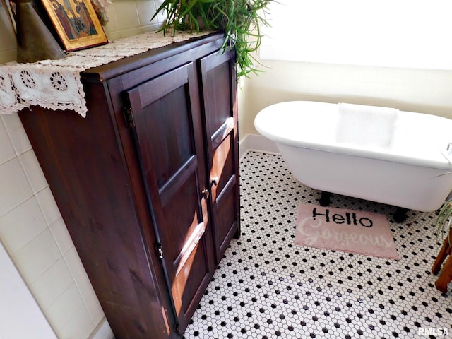 bathroom featuring a freestanding tub and tile patterned flooring