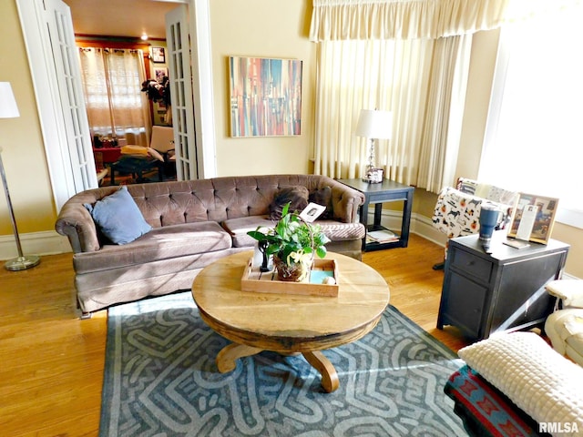 living area with baseboards and wood finished floors