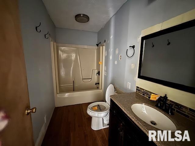 bathroom with tub / shower combination, vanity, toilet, and wood finished floors