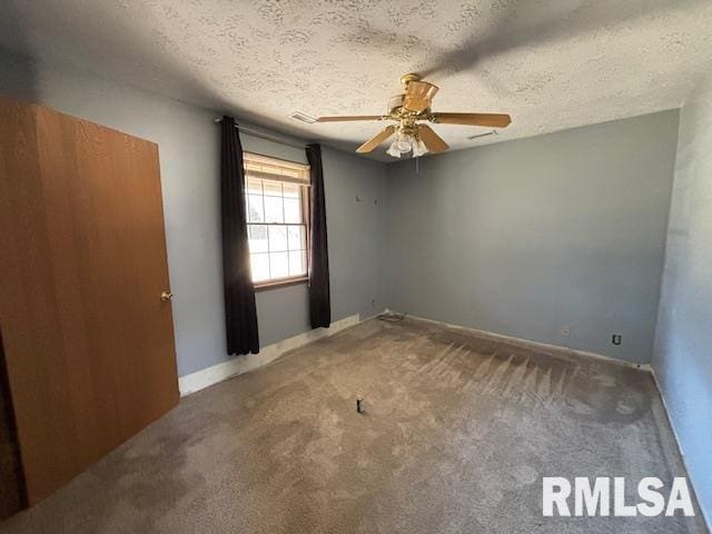 carpeted empty room with a ceiling fan, a textured ceiling, and baseboards