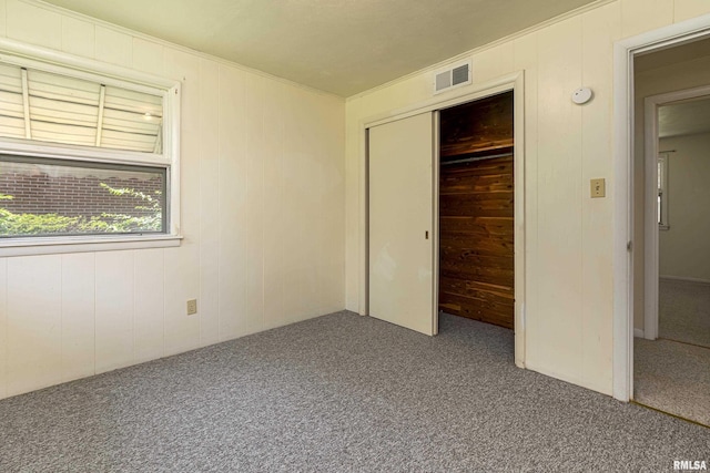 unfurnished bedroom featuring carpet, visible vents, and a closet