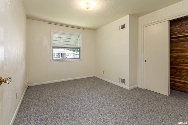 unfurnished bedroom featuring a closet, visible vents, baseboards, and carpet flooring