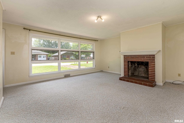 unfurnished living room featuring visible vents, baseboards, ornamental molding, a brick fireplace, and carpet