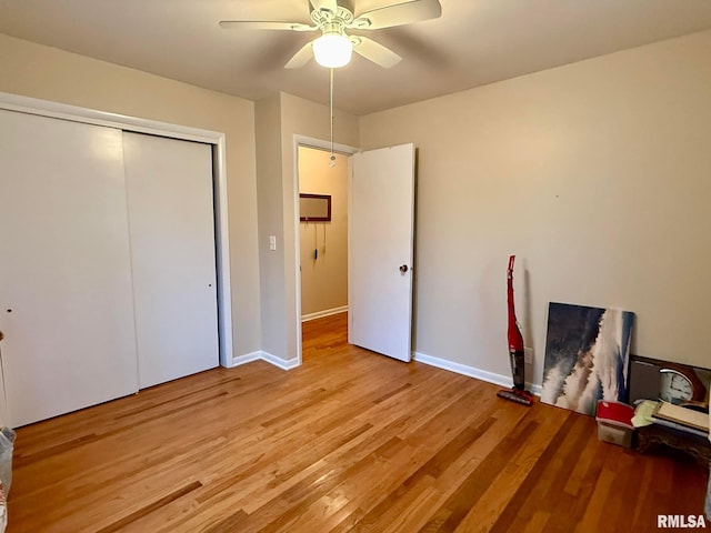 unfurnished bedroom featuring a closet, light wood-style flooring, and baseboards