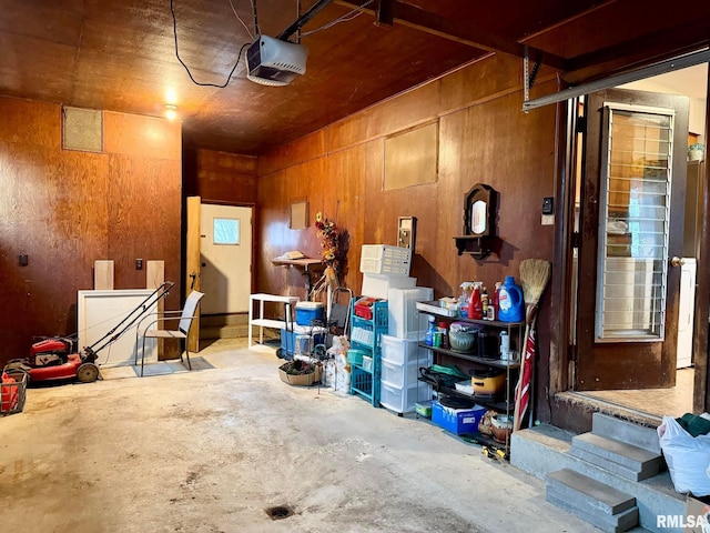 garage featuring a garage door opener and wooden walls