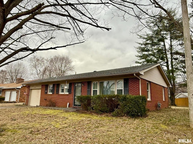 ranch-style house featuring a garage, brick siding, a front lawn, and fence