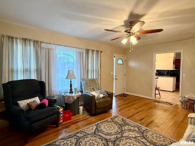 foyer entrance featuring a ceiling fan, baseboards, and wood finished floors