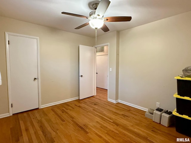 unfurnished bedroom with ceiling fan, wood finished floors, and baseboards