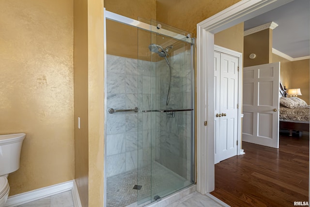 full bathroom featuring baseboards, a stall shower, toilet, and crown molding