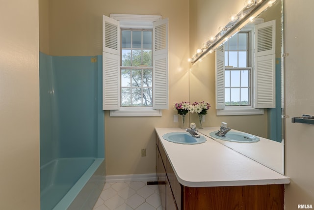 bathroom with vanity, baseboards, and tile patterned floors