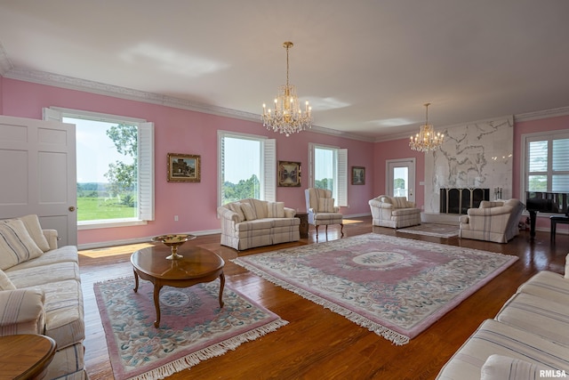 living area with a chandelier, ornamental molding, and wood finished floors