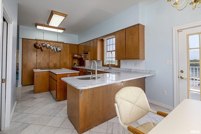 kitchen featuring light countertops, brown cabinets, a sink, and a peninsula