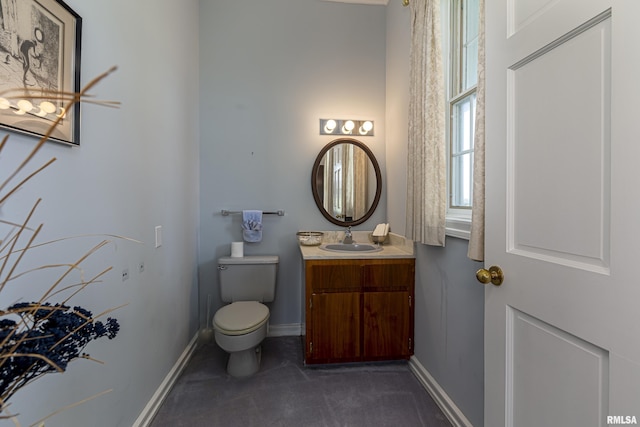 bathroom with vanity, toilet, and baseboards