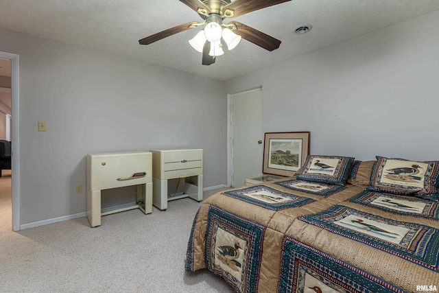 bedroom with light colored carpet, visible vents, a textured ceiling, and baseboards