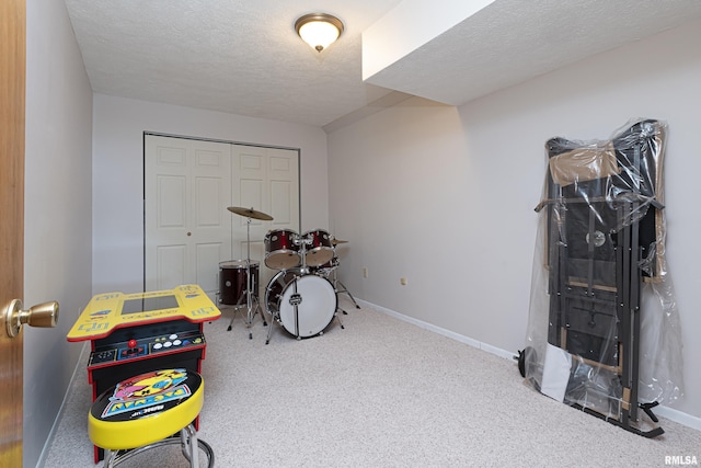 playroom featuring carpet, a textured ceiling, and baseboards