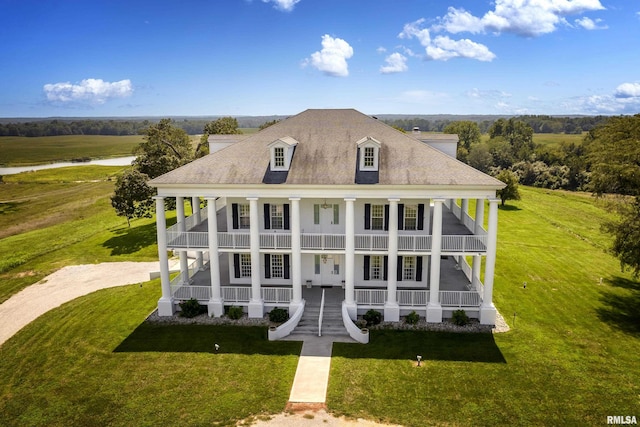 exterior space with a porch, a front yard, driveway, and a shingled roof