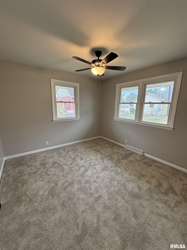 carpeted empty room with ceiling fan and baseboards