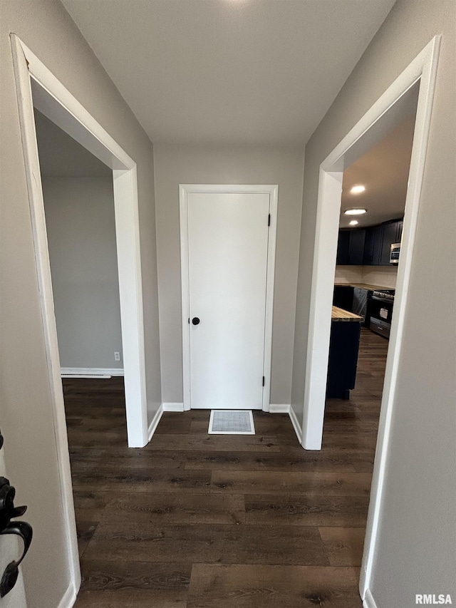 hall featuring baseboards and dark wood finished floors