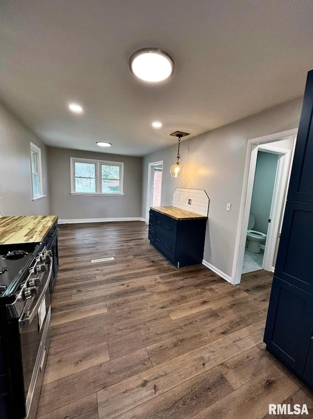 kitchen with dark wood-style floors, wooden counters, and range with gas cooktop