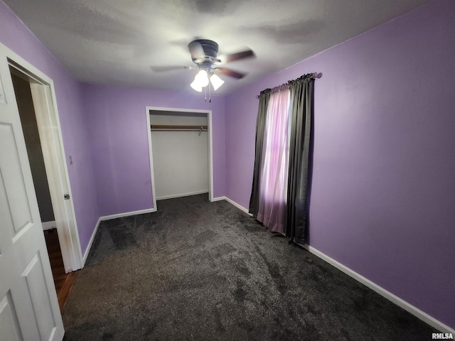 unfurnished bedroom with a closet, dark carpet, and baseboards