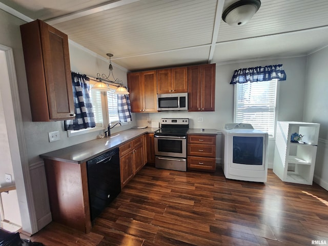 kitchen featuring appliances with stainless steel finishes, washer / clothes dryer, dark wood-style flooring, a healthy amount of sunlight, and a sink