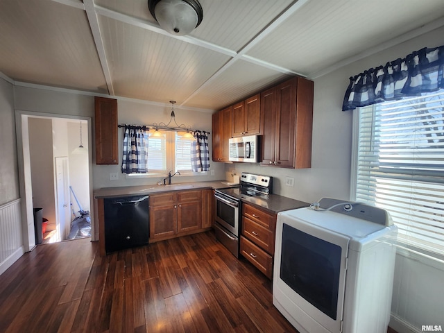 kitchen featuring a sink, appliances with stainless steel finishes, dark wood-style floors, brown cabinetry, and washer / dryer