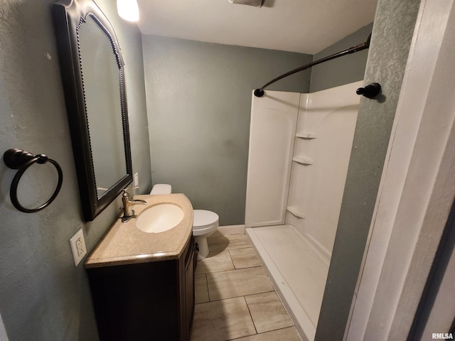 full bath featuring toilet, a shower, and vanity