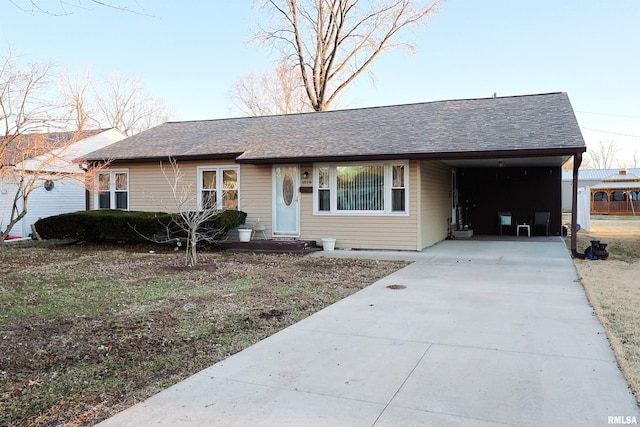 single story home with driveway, a carport, and roof with shingles