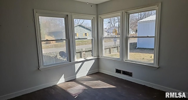 spare room with baseboards and visible vents