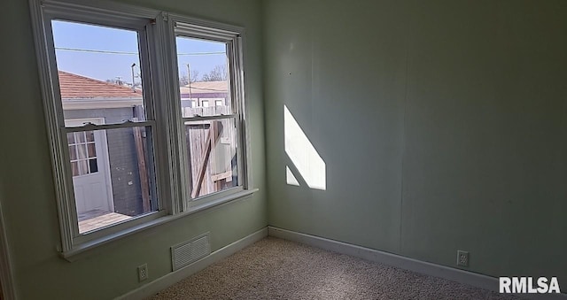 unfurnished room featuring carpet flooring, visible vents, and baseboards