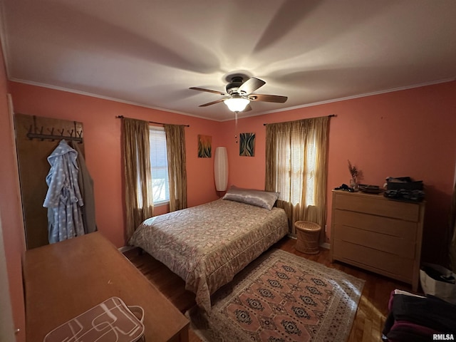 bedroom with wood finished floors, a ceiling fan, and crown molding