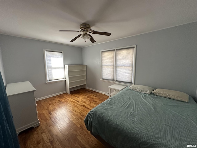 bedroom with ceiling fan, baseboards, and wood finished floors